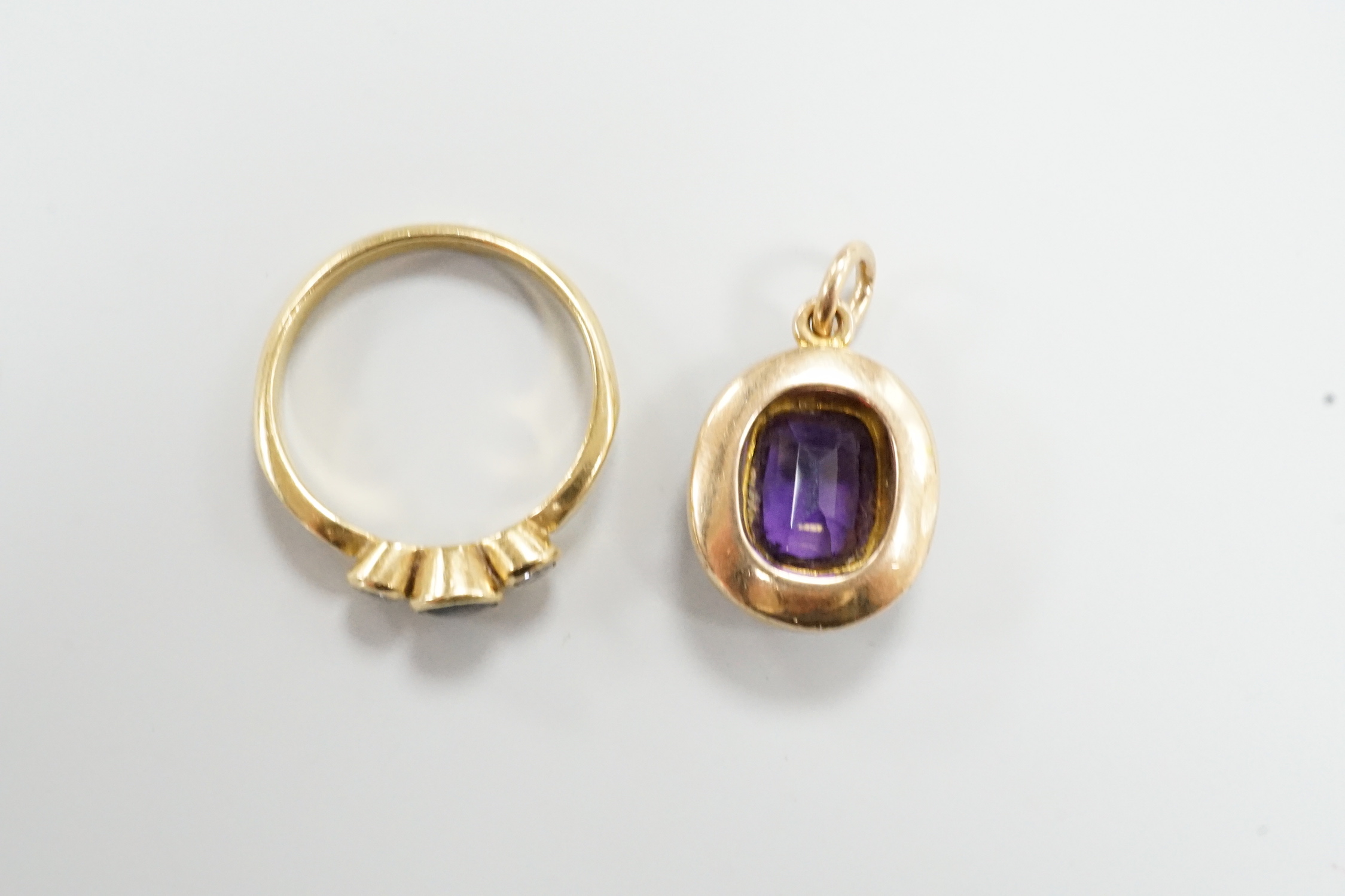 A yellow metal, sapphire and diamond set three stone ring, size O/P and a yellow metal, amethyst and seed pearl set pendant, gross weight 6.8 grams.